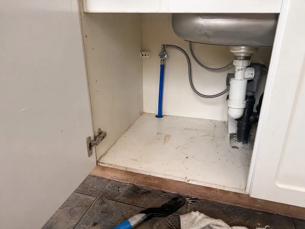 The same cupboard with a new blue supply pipe and stop tap, Nottingham