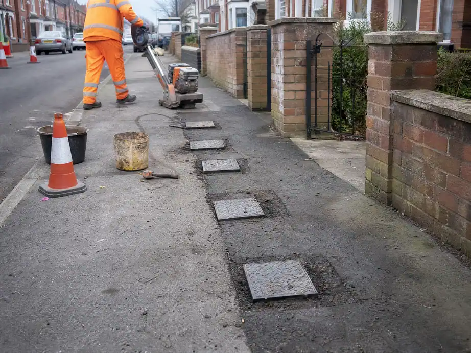 Row of stop-tap covers in the pavement outside terraced houses with shared supplies, Nottingham
