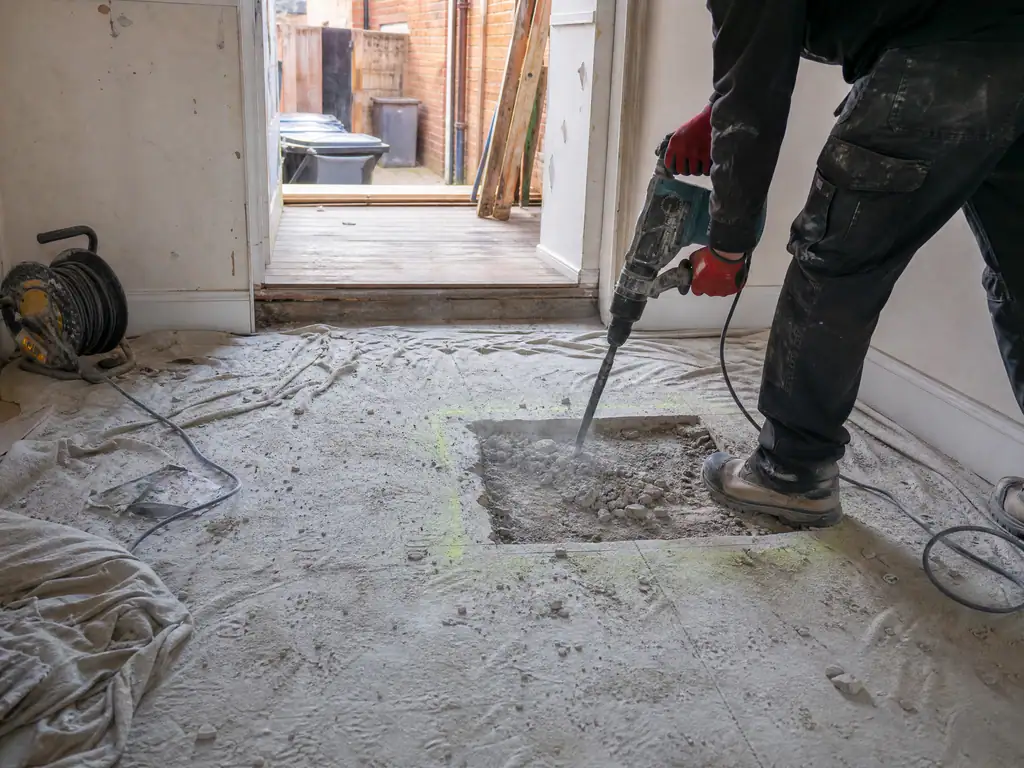 SDS drill breaking out a small square of concrete floor over a leak, Nottingham