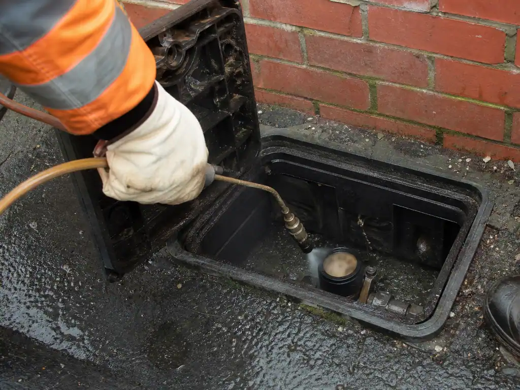 Water meter in a pavement boundary box being checked by torchlight outside a terraced house in Nottingham